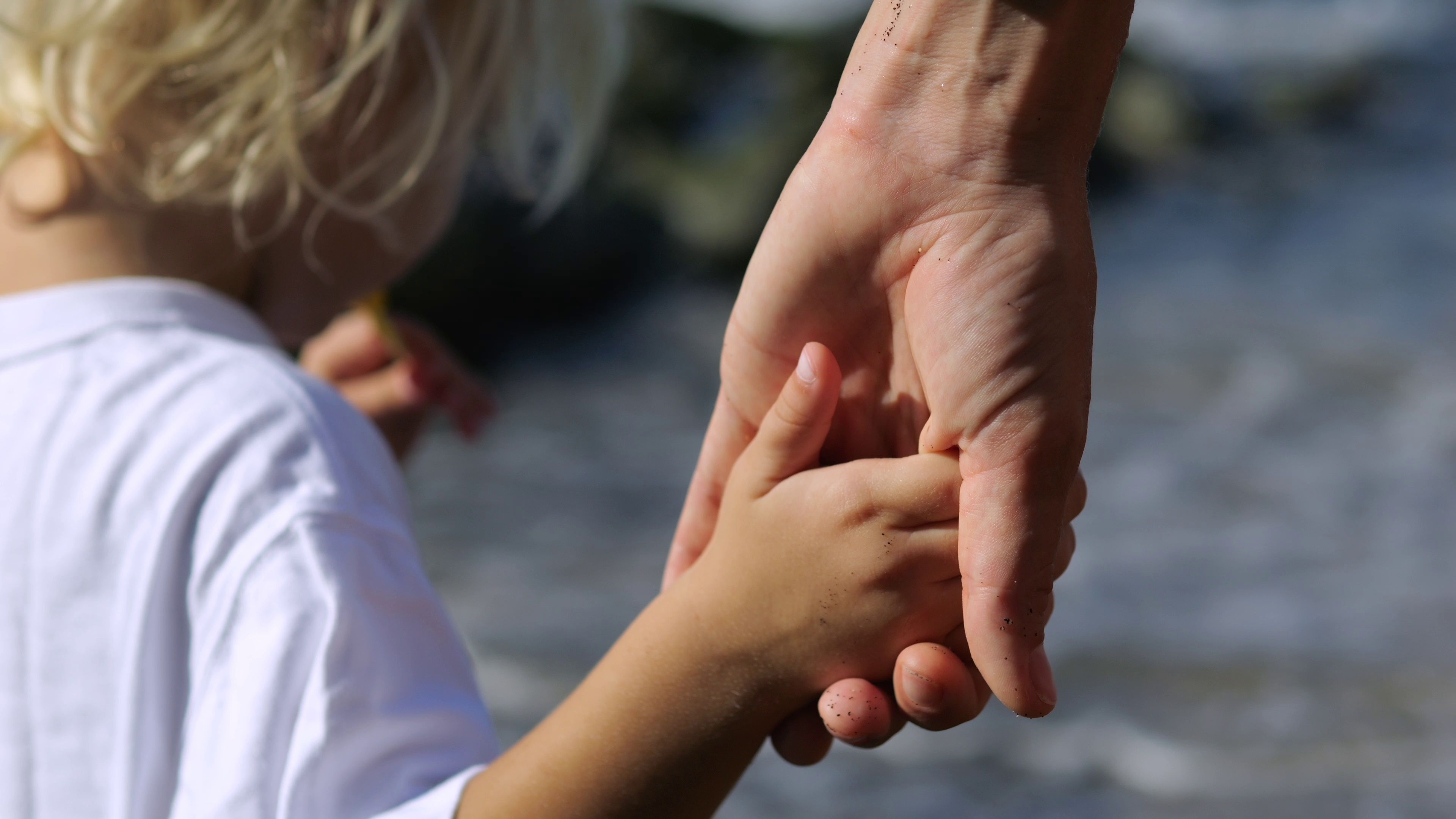 A parent and child hold hands.
