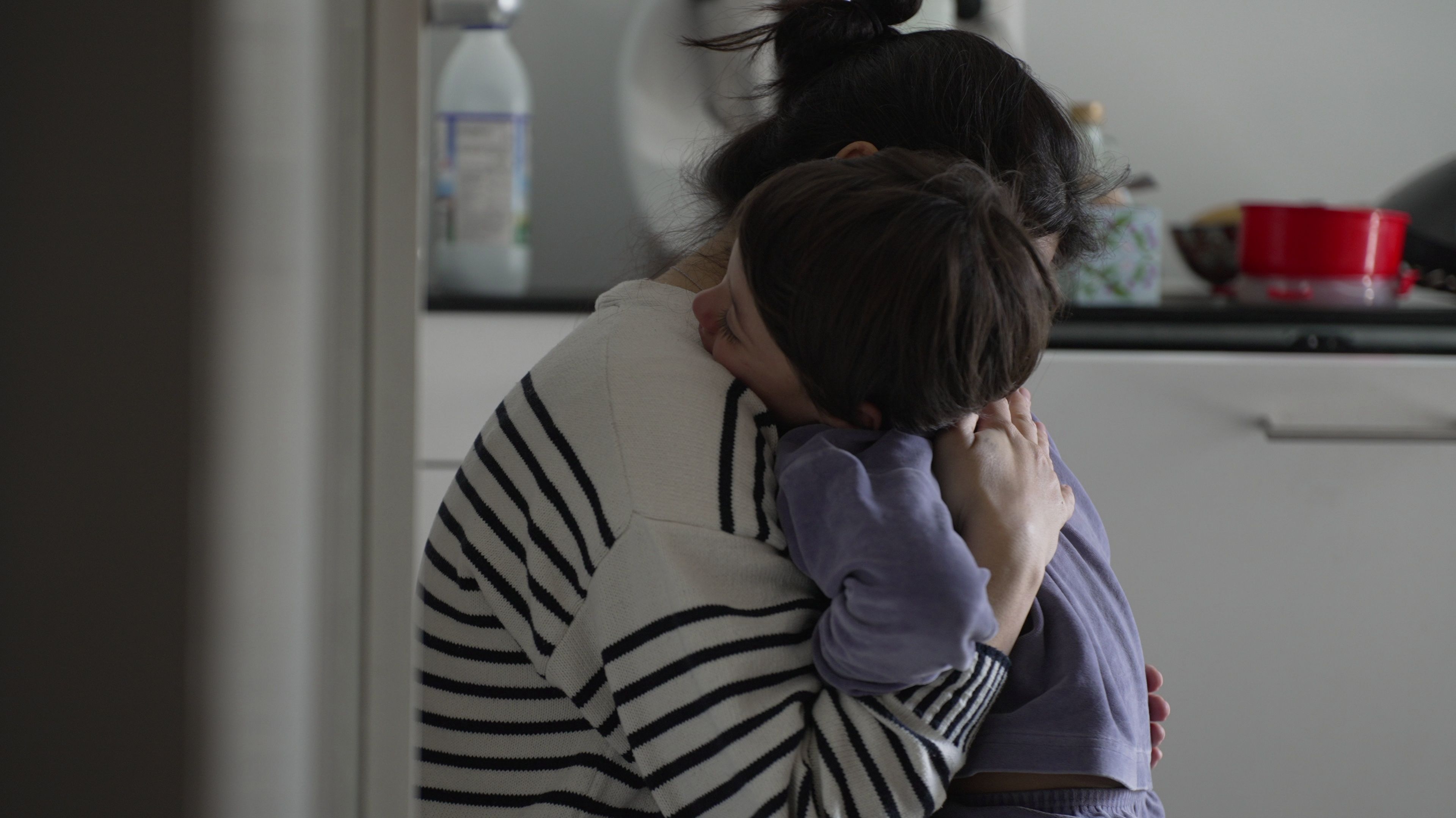 A mother hugs her child.