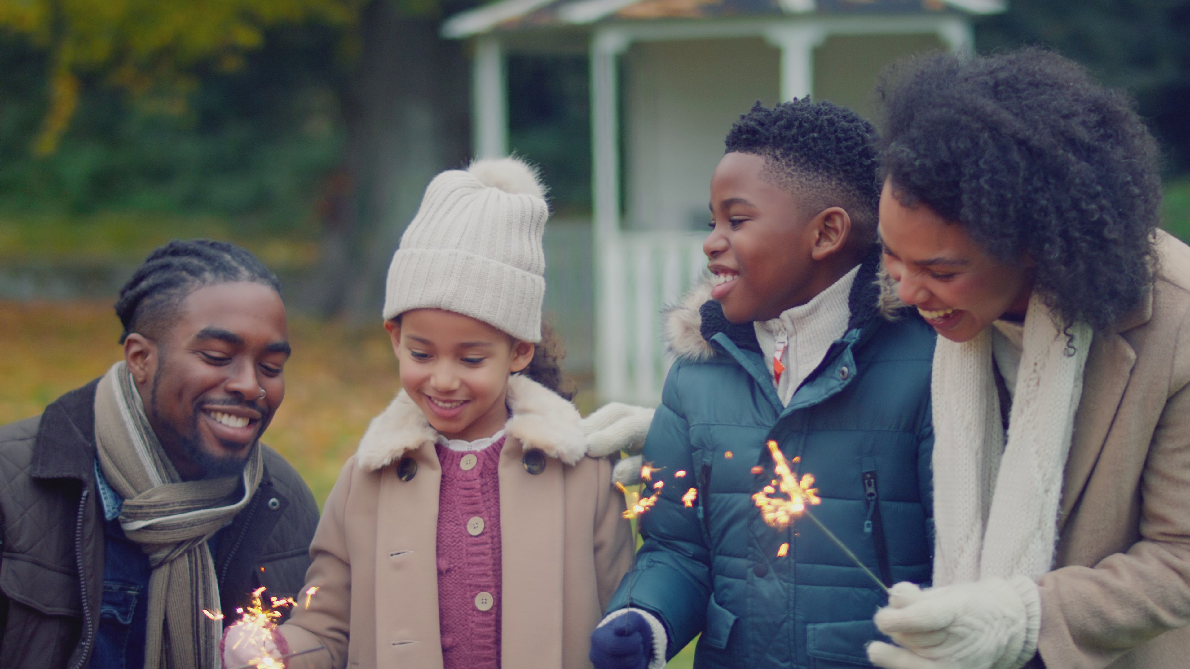 A smiling black family holding sparklers
