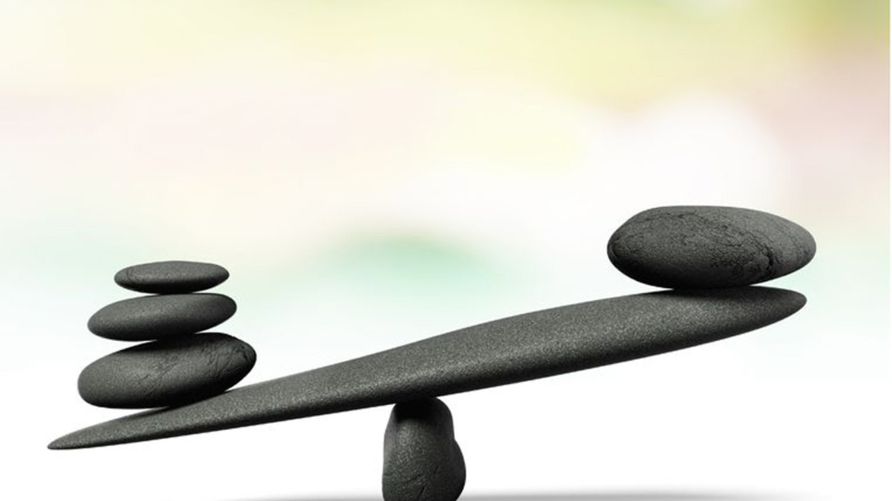 Picture of a Stone Seesaw with 3 rocks on the left and one bigger rock on the right.