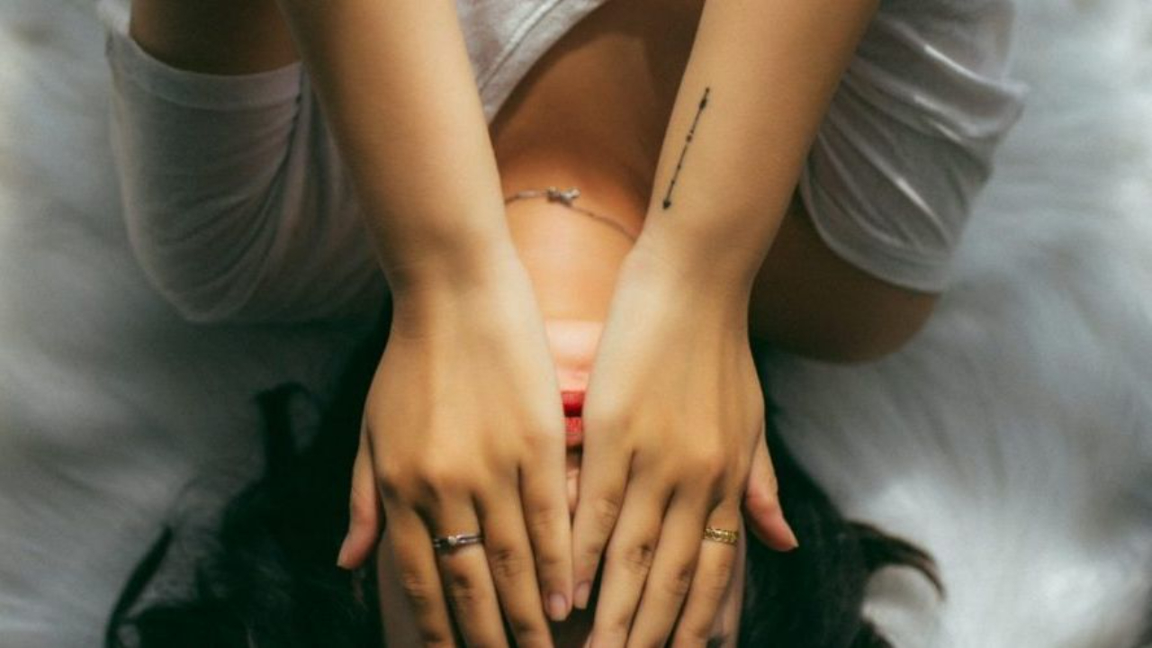 Woman lying down with hands over her eyes