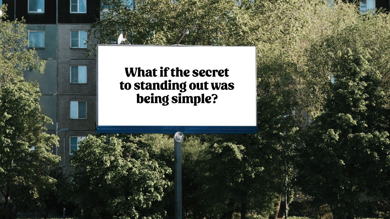 Billboard with text "What if the secret to standing out was being simple?" surrounded by trees - marketing clarity beats creativity concept
