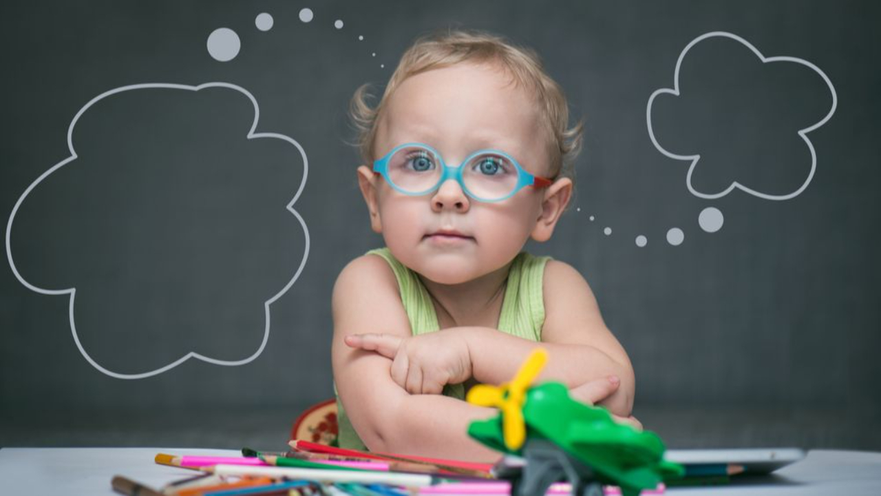 young girl in front of chalk board thinking