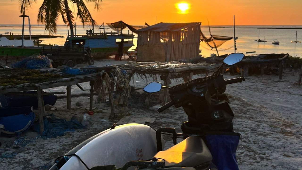 tropical island sunset with surfboards on scooter overlooking ocean