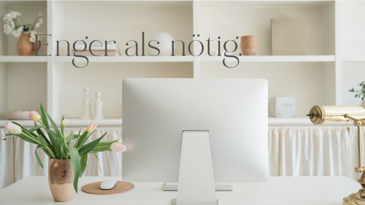 Schreibtisch mit Computer von hinten, Strauß Tulpen daneben; im Hintergrund ein Regal mit wenigen Deko-Objekten; ruhige helle Szene