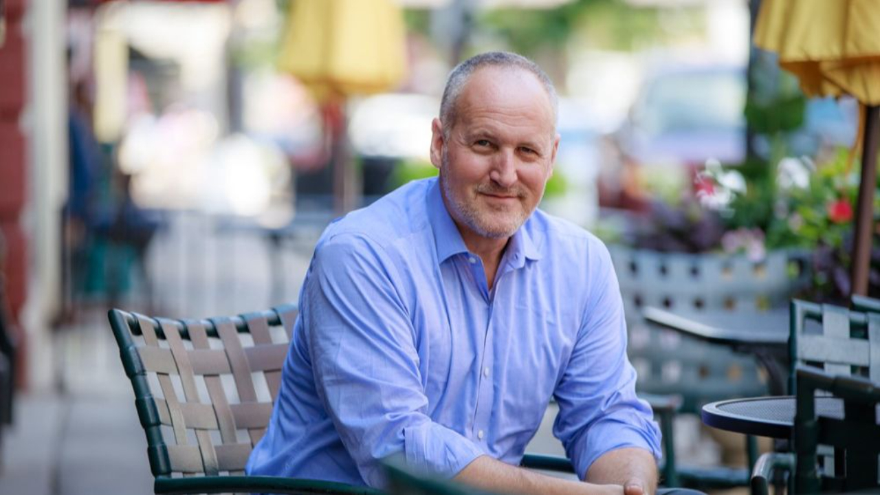 Confident middle-aged man sitting outdoors at a cafe, symbolizing self-reflection, clarity, and personal growth