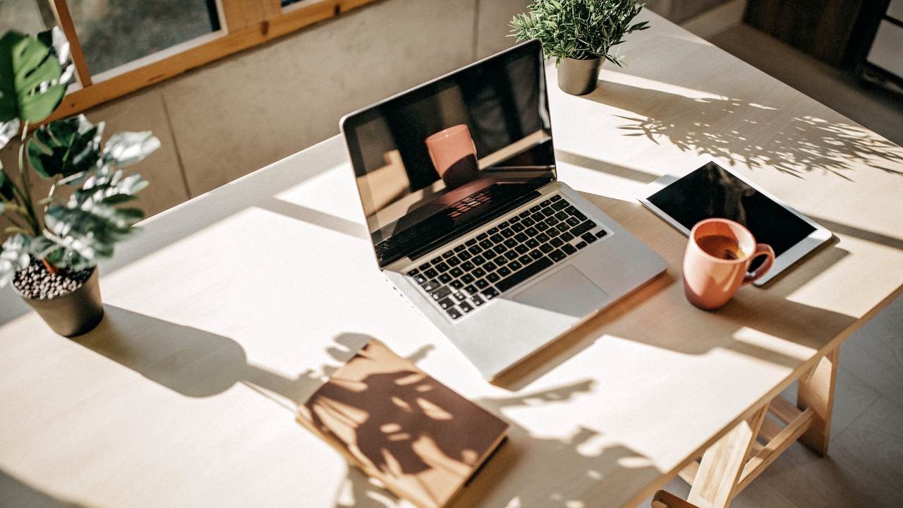 Mature life coaching office desk with laptop open and coffee