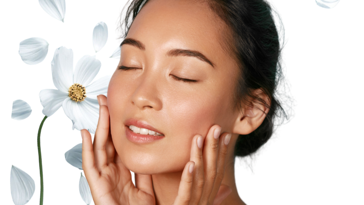 healthy looking woman with glowy skin and a daisy and petals in the background