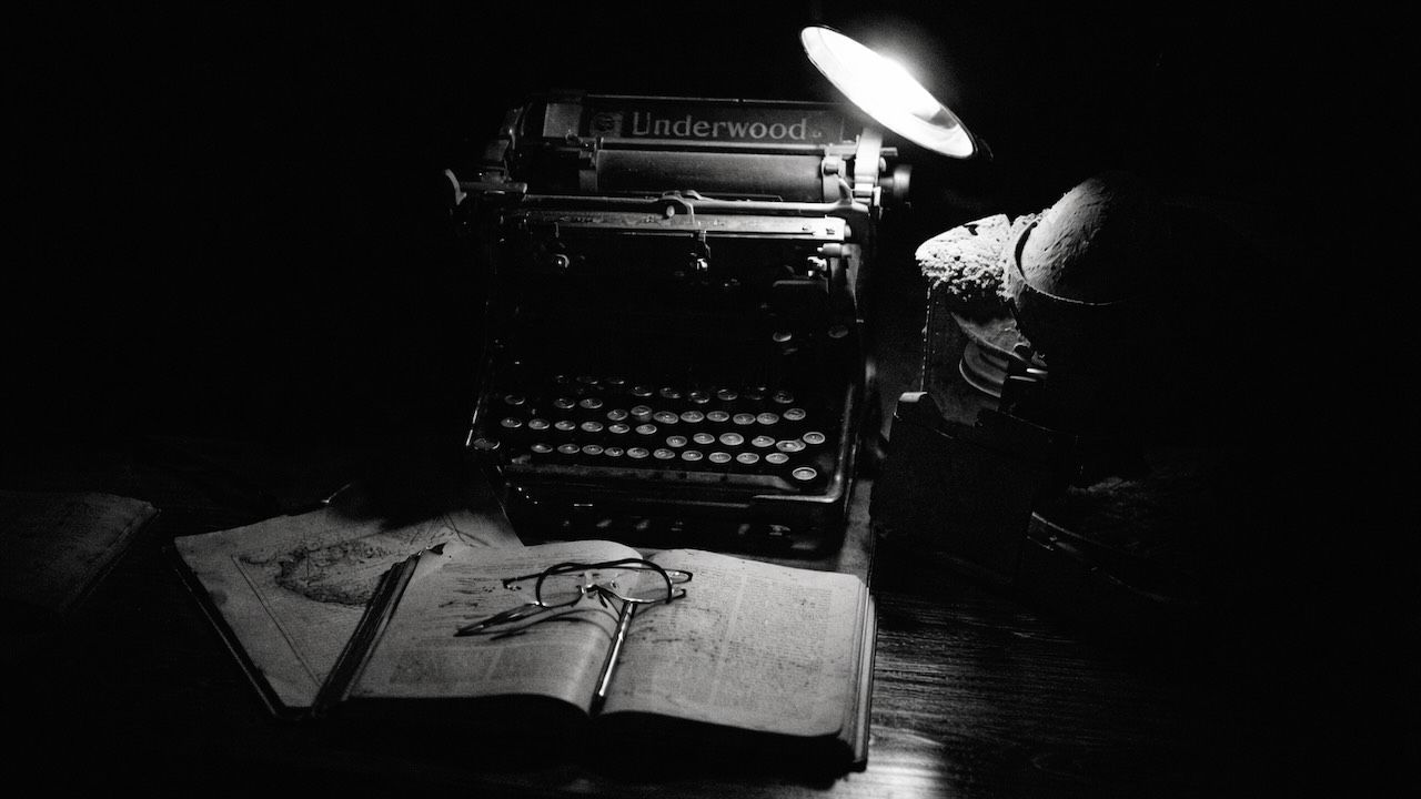 typewriter and glasses on books at night
