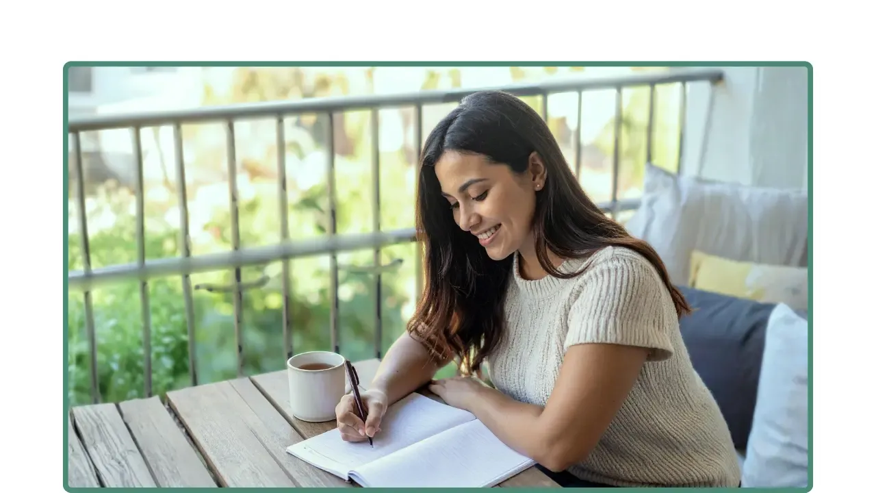 Mujer profesional escribe en un cuaderno con luz natural; registra avances