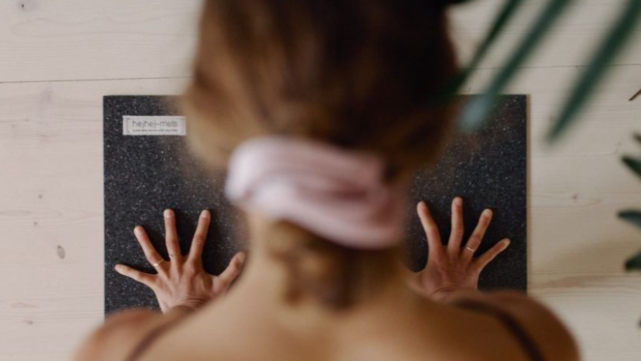 Woman pressing into a workout mat, representing strength training and boosting energy through proper nutrition and exercise.