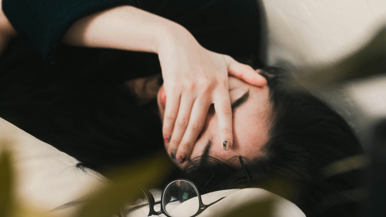 An exhausted looking woman covering her eyes