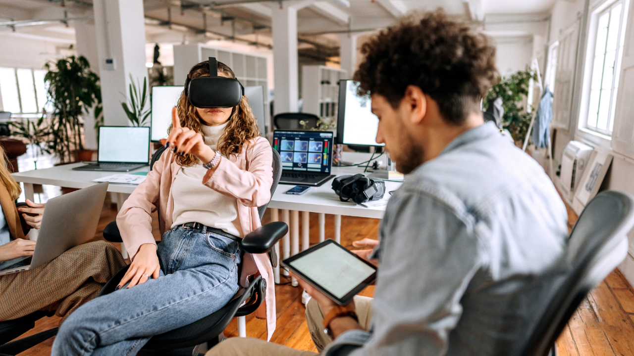 Woman wearing VR headset and a man with a tablet.