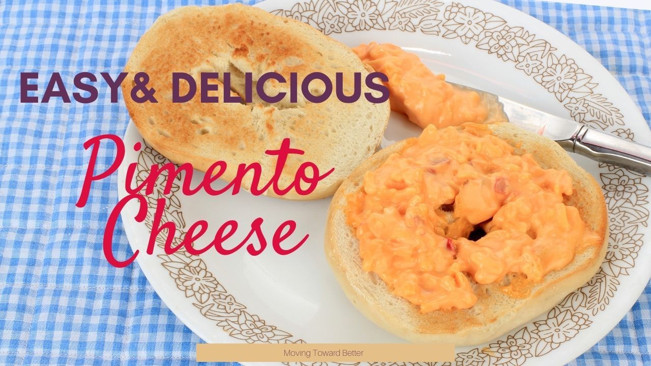 Pimento cheese spread on a bagel sitting on a country style plate with a gingham tablecloth for the Moving Toward Better Pimento Cheese Recipe blog post