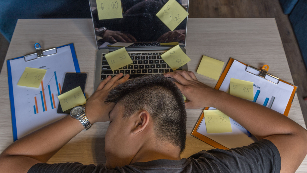 Technician asleep on desk with appointment post-it notes
