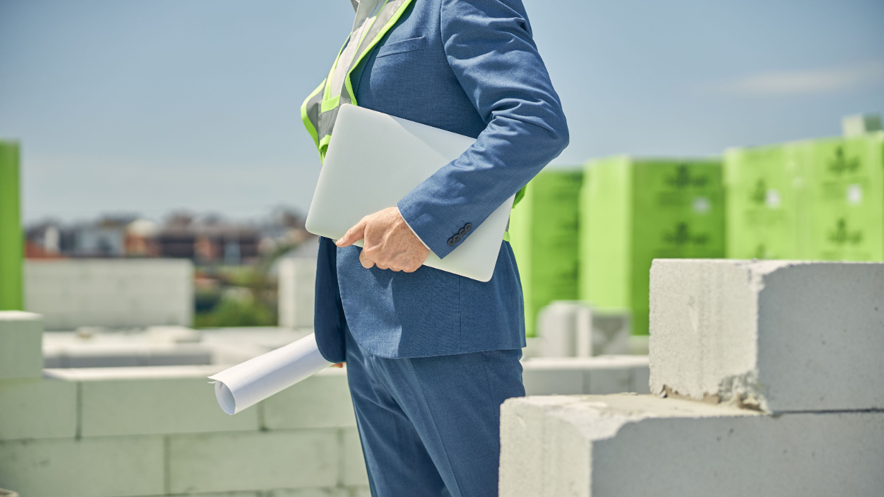 Business Man with Blueprint at Construction Site