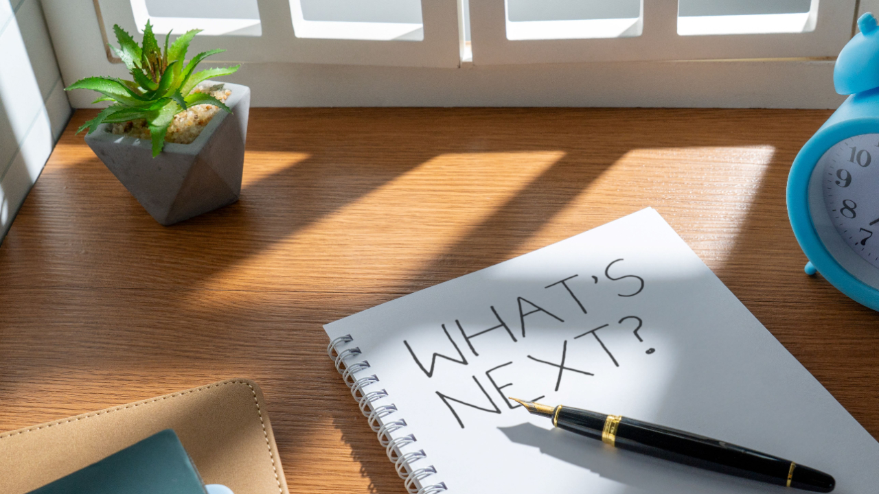 notepad on a table with What’s Next written on it