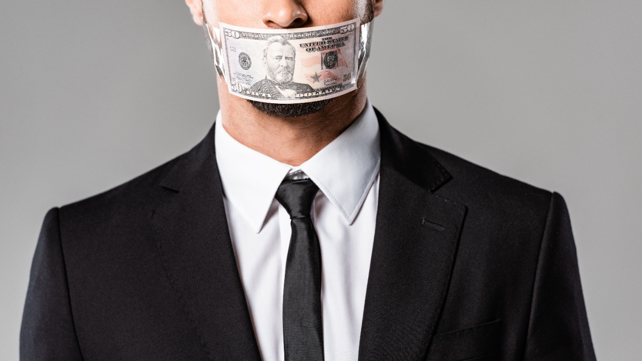 Businessman with mouth covered by a $50 bill