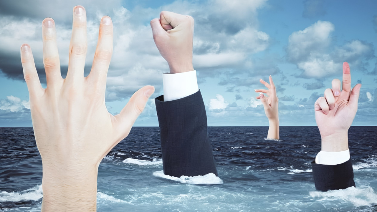 Hands from business people extending up through the surface of an ocean