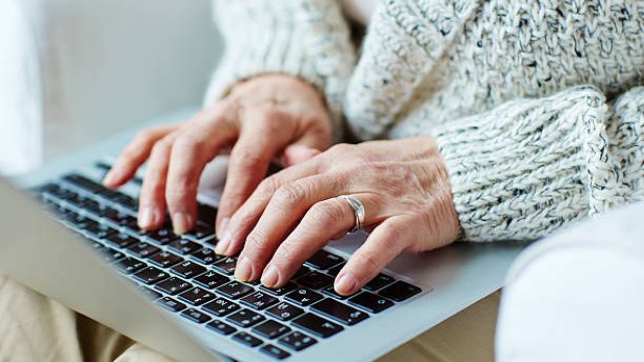 Voksne hender på tastaturet på en laptop