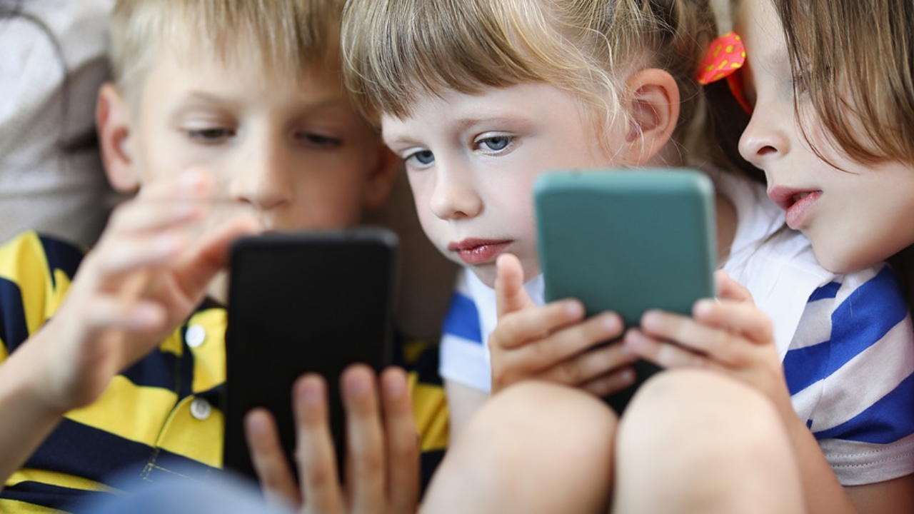 Group of children playing on their mobile phones