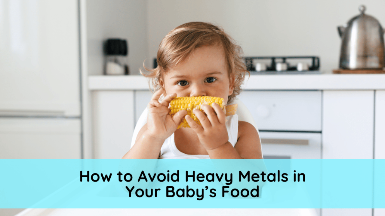 A baby eats corn on the cob in a white kitchen avoiding heavy metals in baby food pouches.