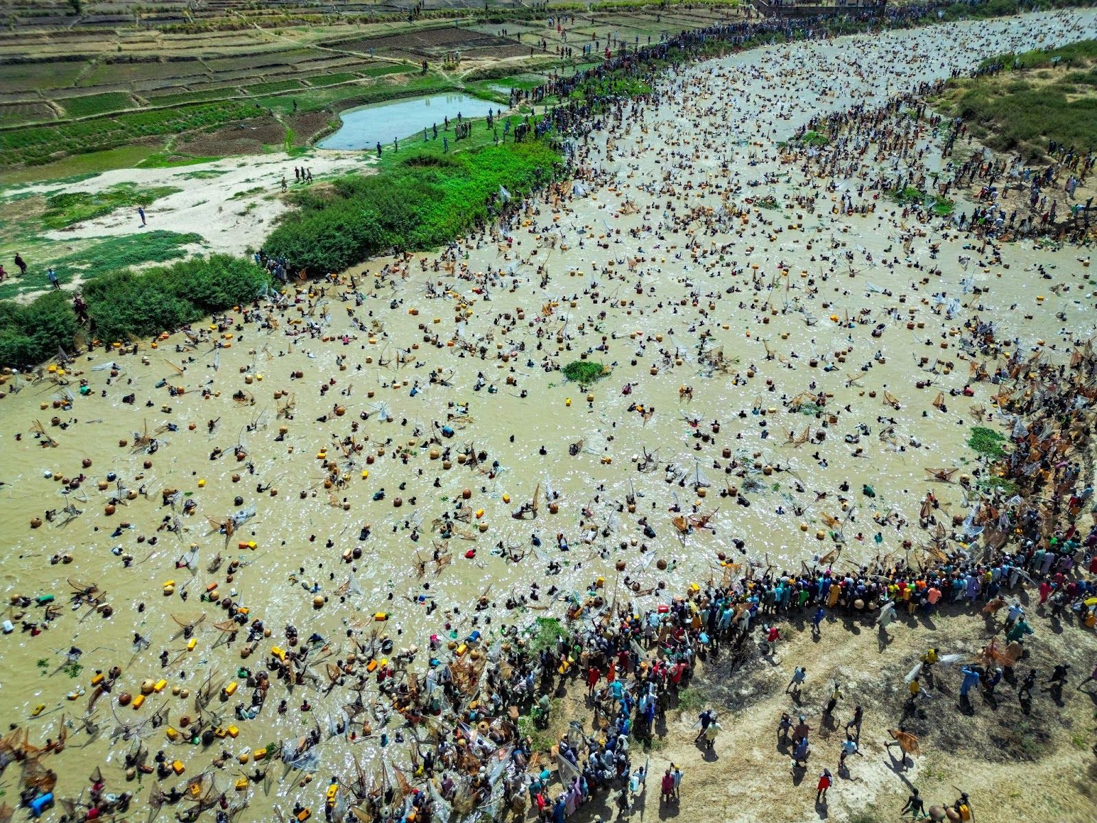 Fishermen surge into the river as the crowd watches at the Argungu International Fishing Festival. © Amazing Aerial / Abdulrahman Abubakar