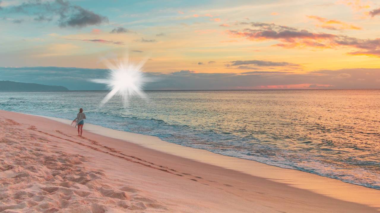  A person walks along the shoreline at sunset, leaving footprints in the sand as the waves gently roll in, symbolizing peace, reflection, and connection with nature.