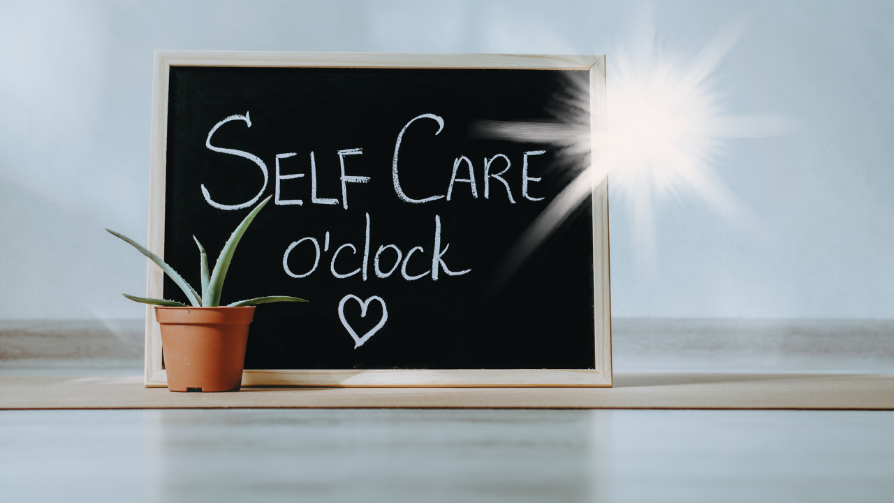 chalkboard sign reading “Self Care o’clock” beside a small potted plant, symbolizing rest, renewal, and emotional balance