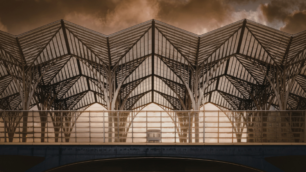 Architectural structure with repeating geometric steel framework, forming a strong, symmetrical design against a dramatic sky, symbolizing stability, intentional design, and the strength of well-built foundations