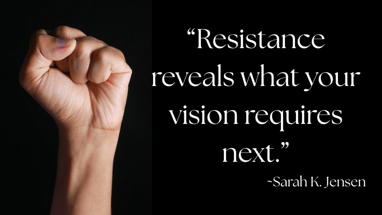 Raised fist against a dark background symbolizing strength and determination, paired with the quote “Resistance reveals what your vision requires next.” — Sarah K. Jensen