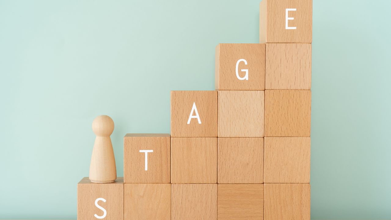 word stage spelled on stacked blocks with pawn piece on bottom stair