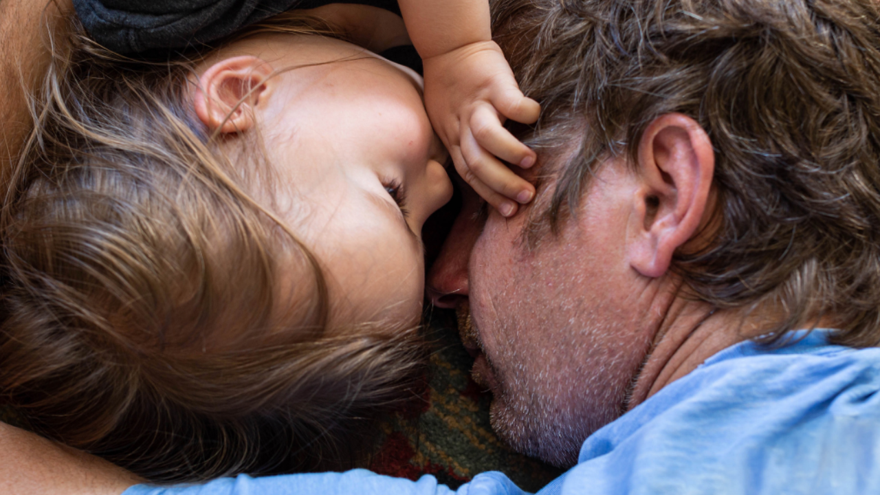 An image of a dad and his daughter cuddling.