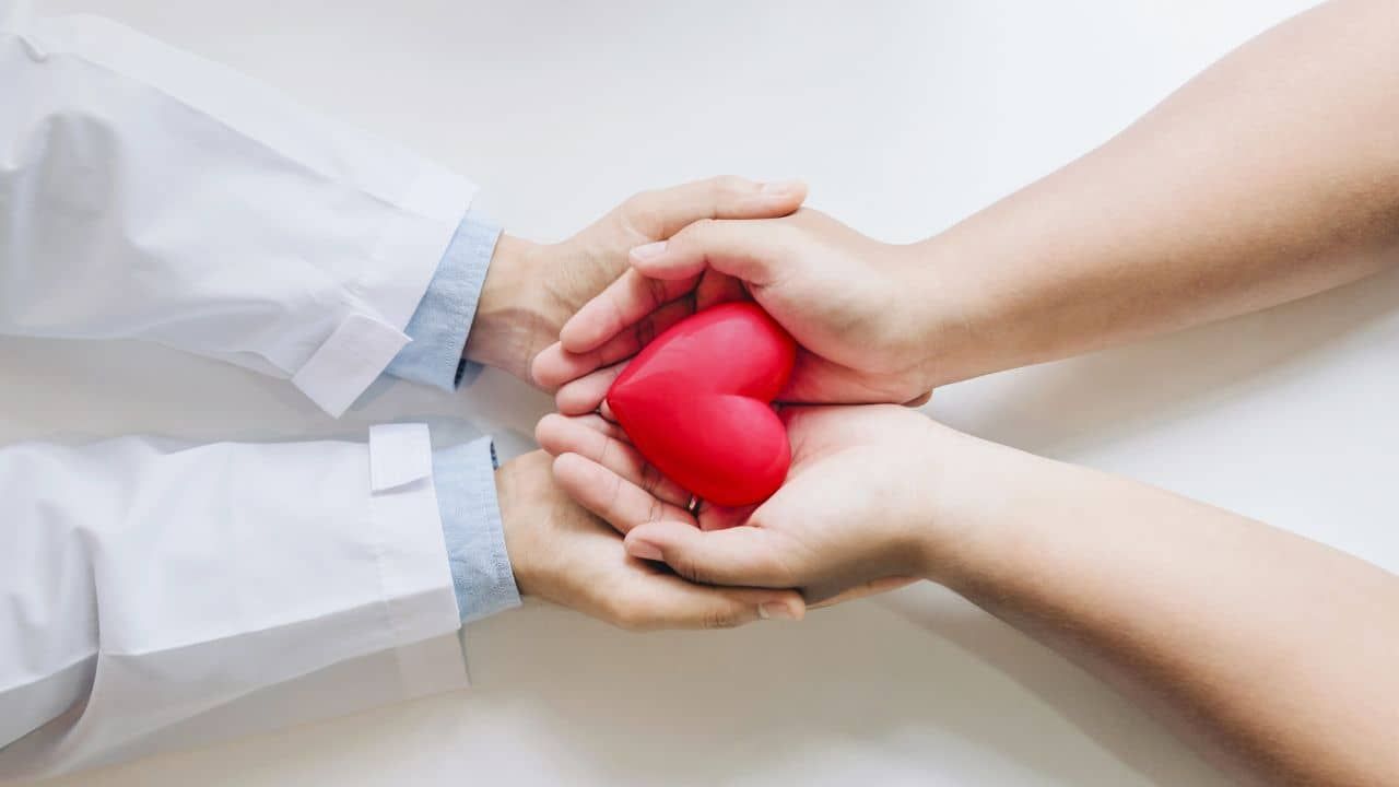 Healthcare provider and parent holding a heart to represent supportive medical decision-making