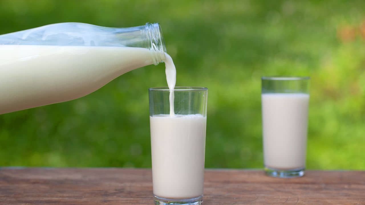 Milk pouring into a glass representing how much milk a baby needs per day