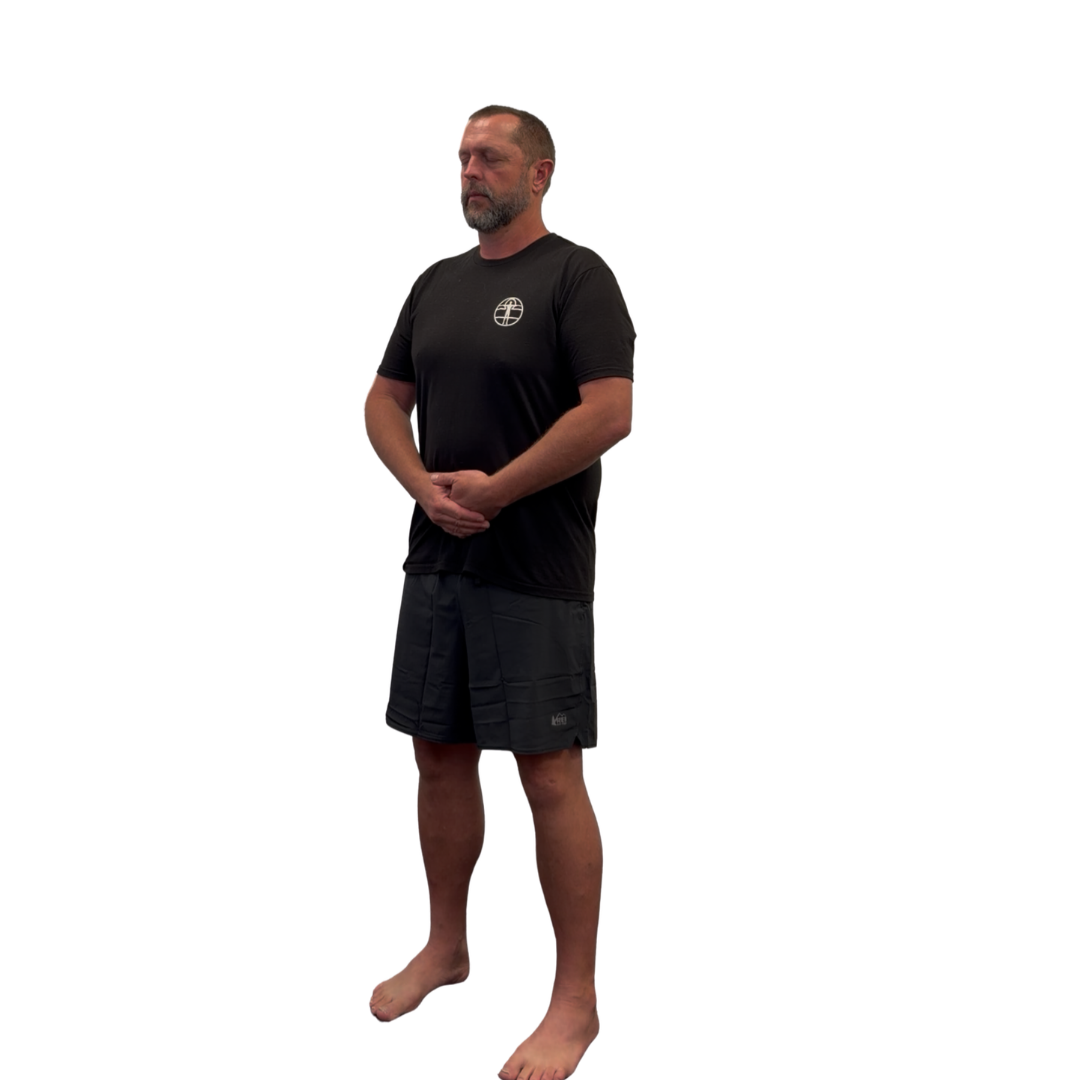 Isaac Osborne standing barefoot with his hands resting at his lower abdomen