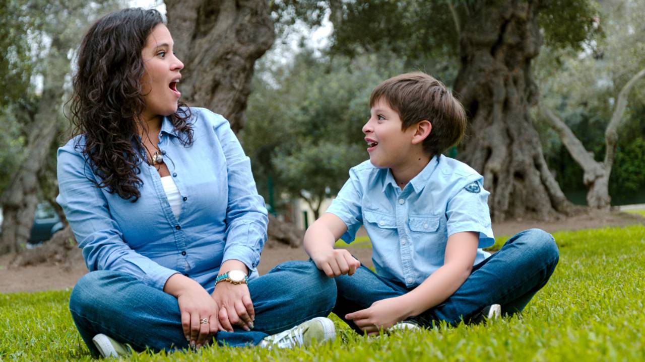 Mother and son sitting in a field, enjoying quality time together
