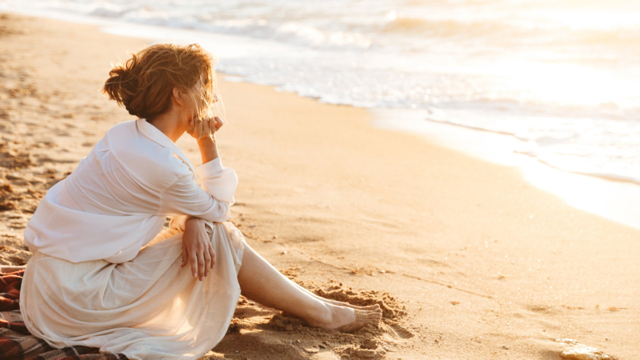 Woman looking out to sea reflecting on well-being and self growth