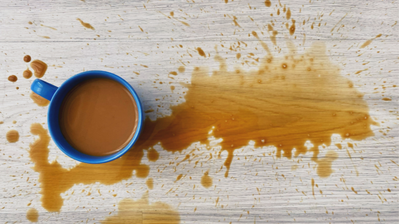 Spilled coffee on wooden floor with morning chaos vibe