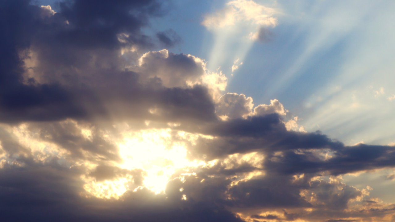 Sun breaking through dark clouds, symbolising market uncertainty giving way to clarity