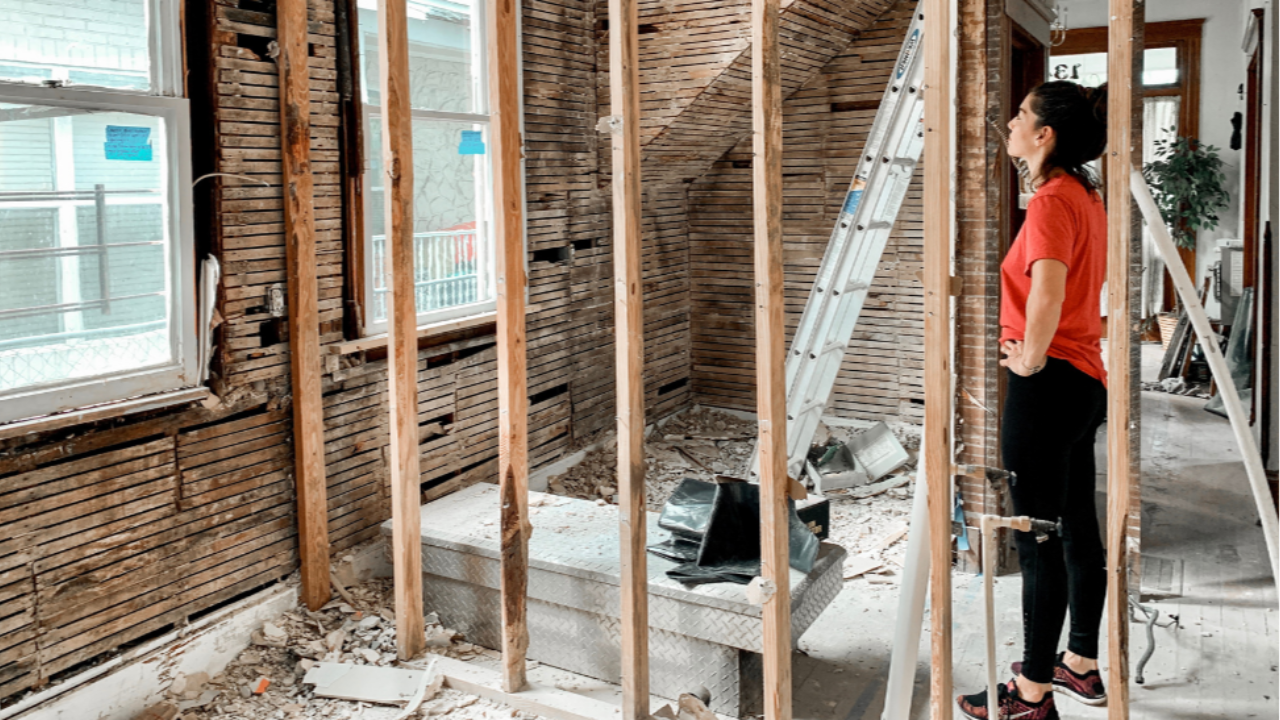 A woman standing and observing a room under renovation