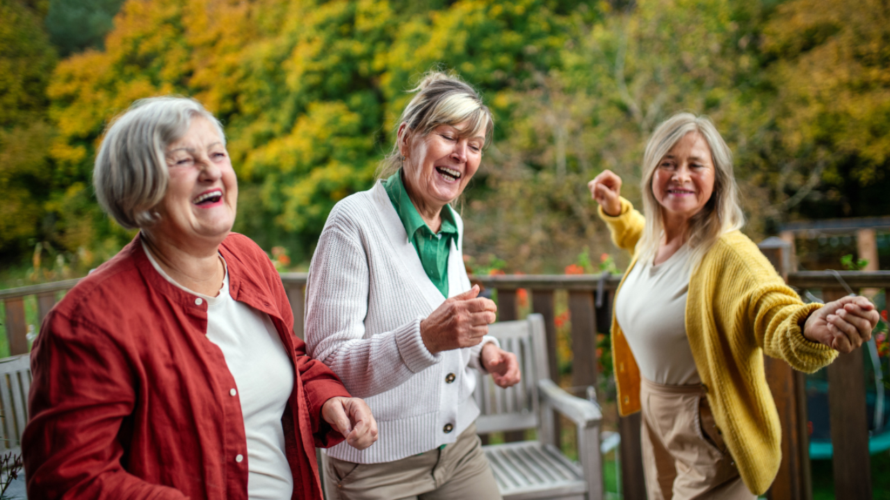 Three joyful women laughing together, showing connection and happiness