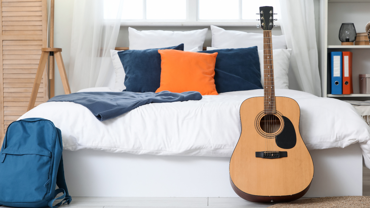 Tidy bedroom with a backpack and guitar left behind, symbolising a quiet house and missing children