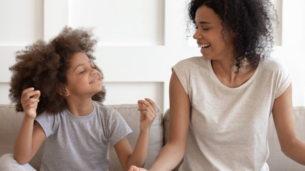 adult and child sitting on couch, smiling