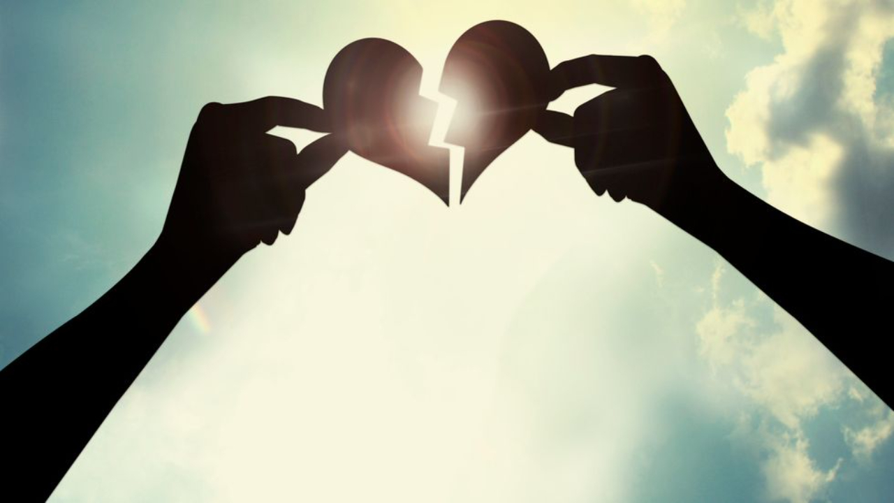 Hands reaching up and each holding a piece of a broken or ripped apart heart. Grief counseling in Michigan can help you feel more connected to yourself again. Reach out for therapy for grief and loss in Plymouth, MI here!