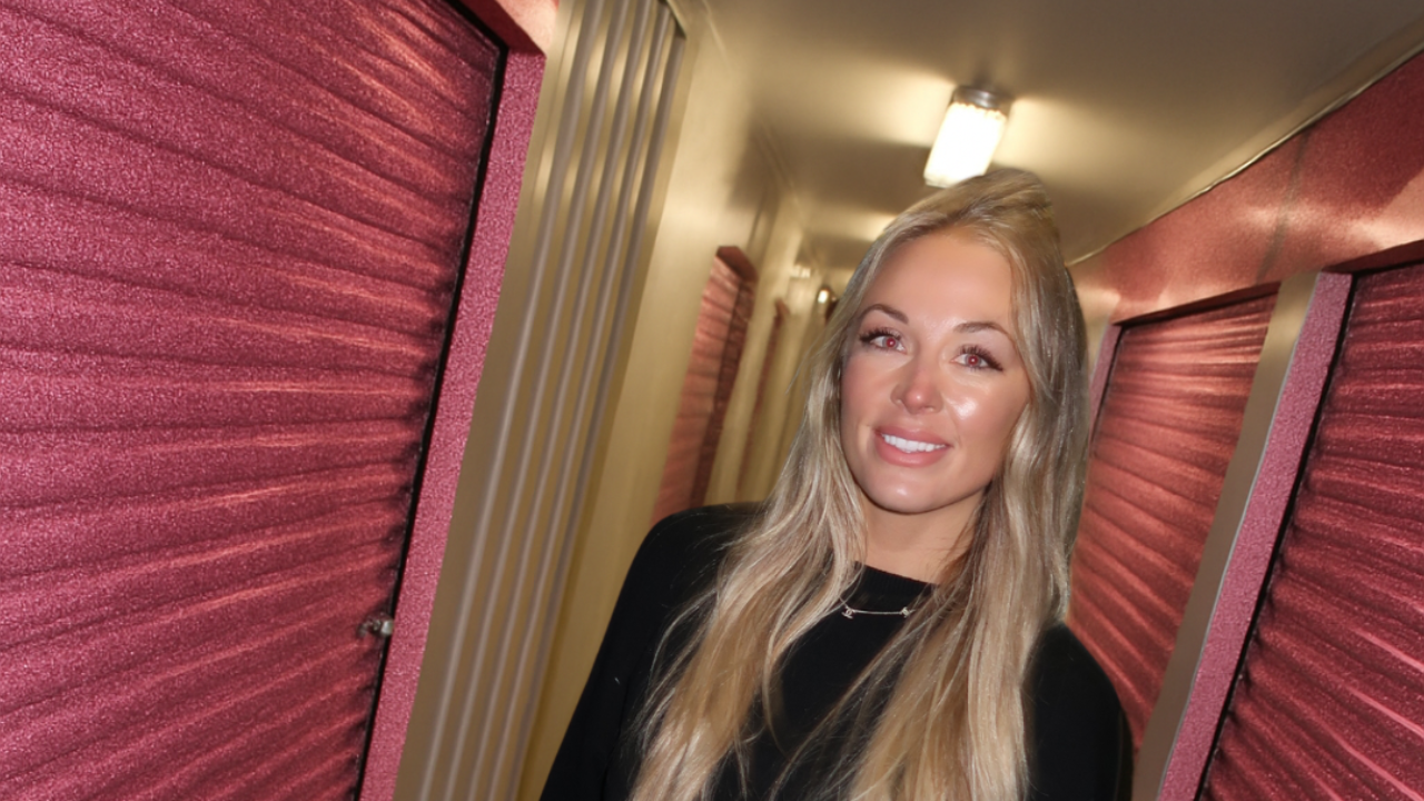 Brittany Arnason in a self-storage facility with pink doors.
