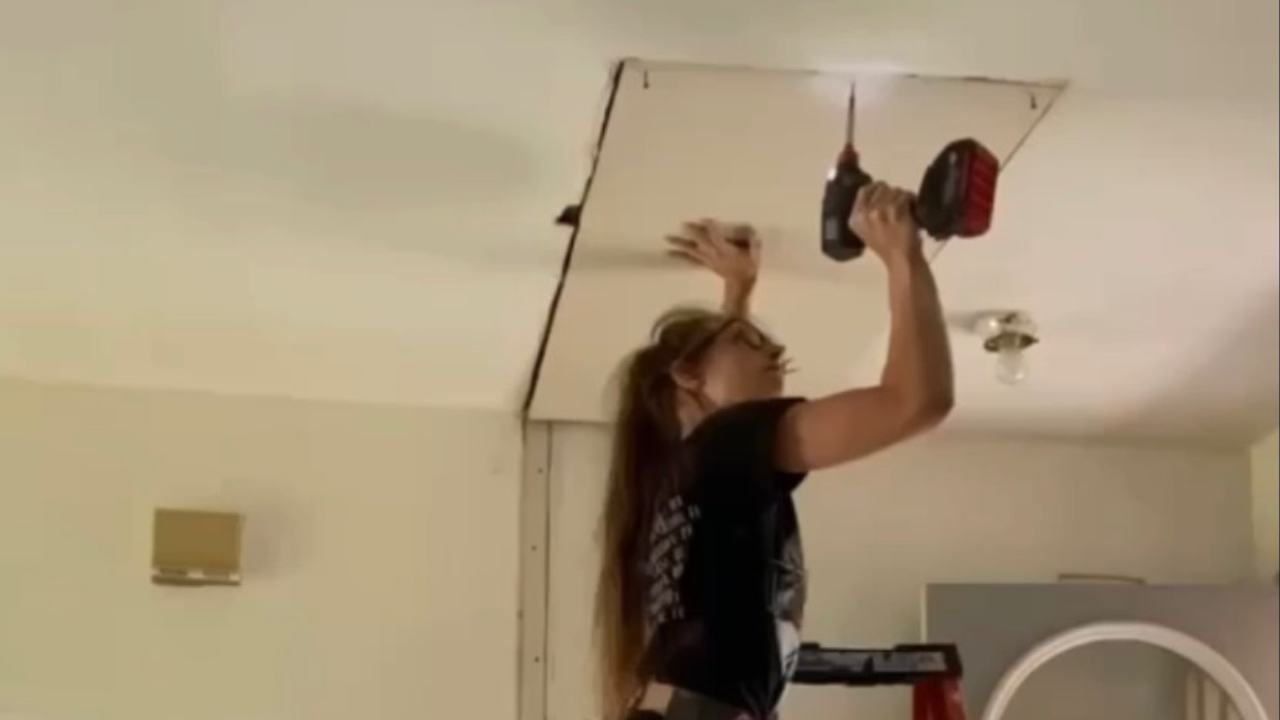 Brittany Arnason drilling a board into a ceiling