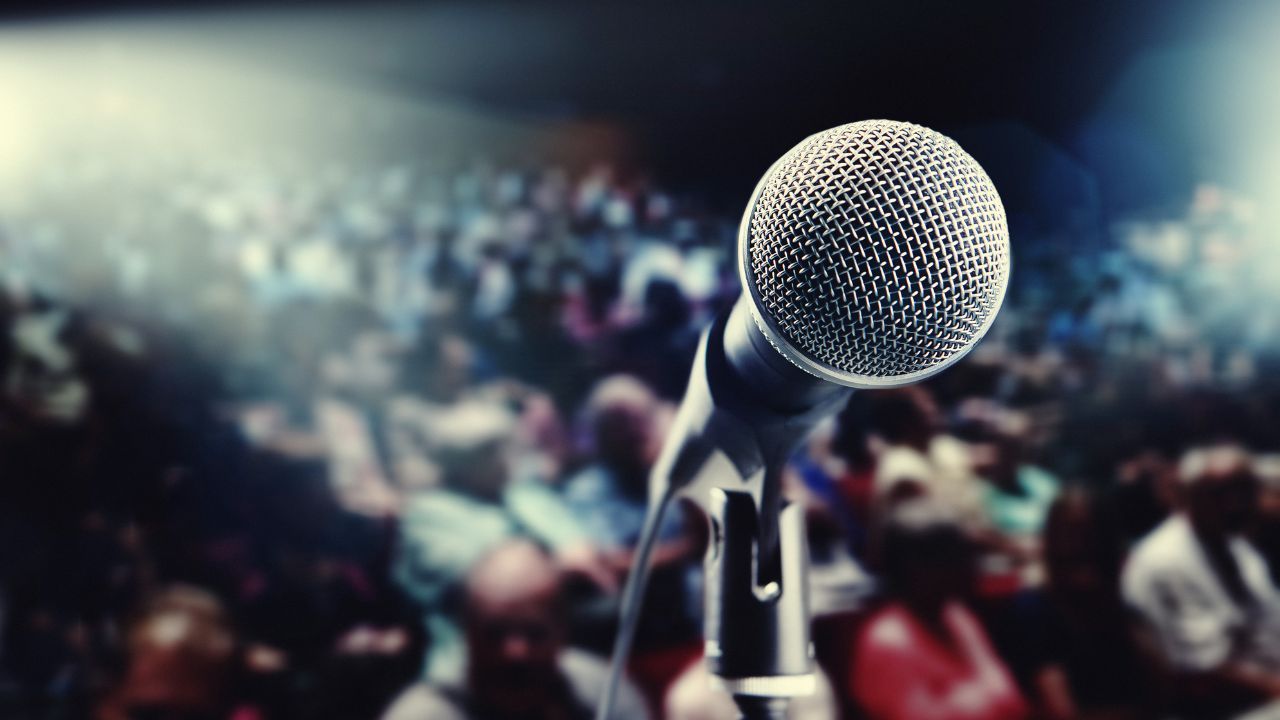 view of audience from stage behind a microphone