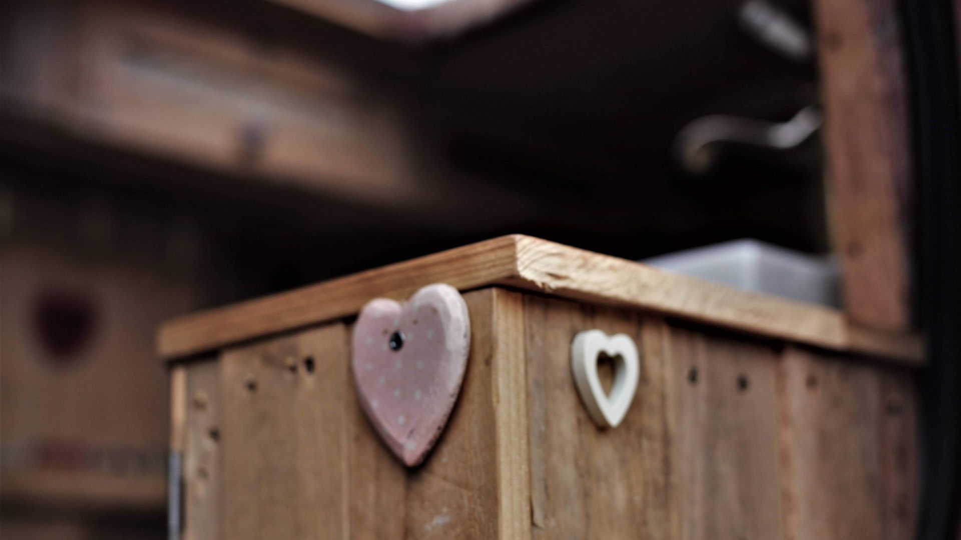 A shot of the entrance to our camper showing a wooden cupboard with wooden hearts on each side.