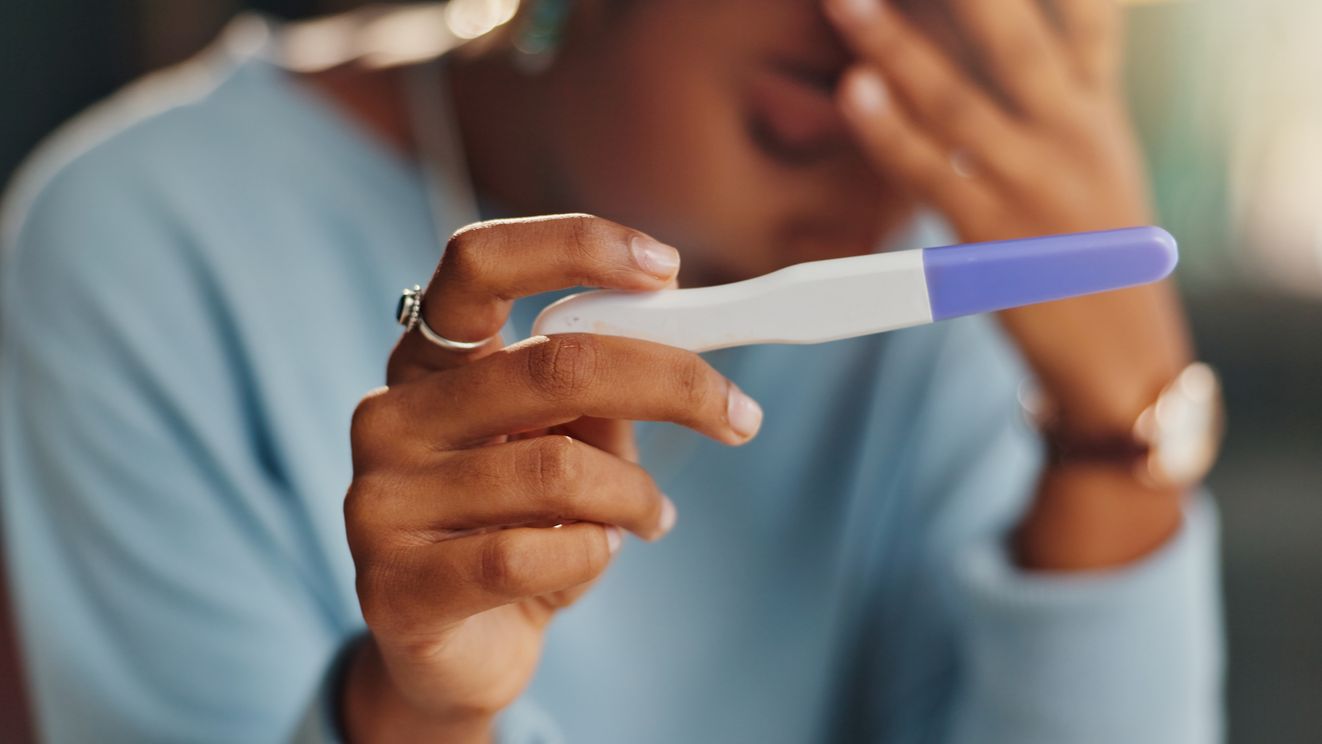 woman disappointed holding a pregnancy test